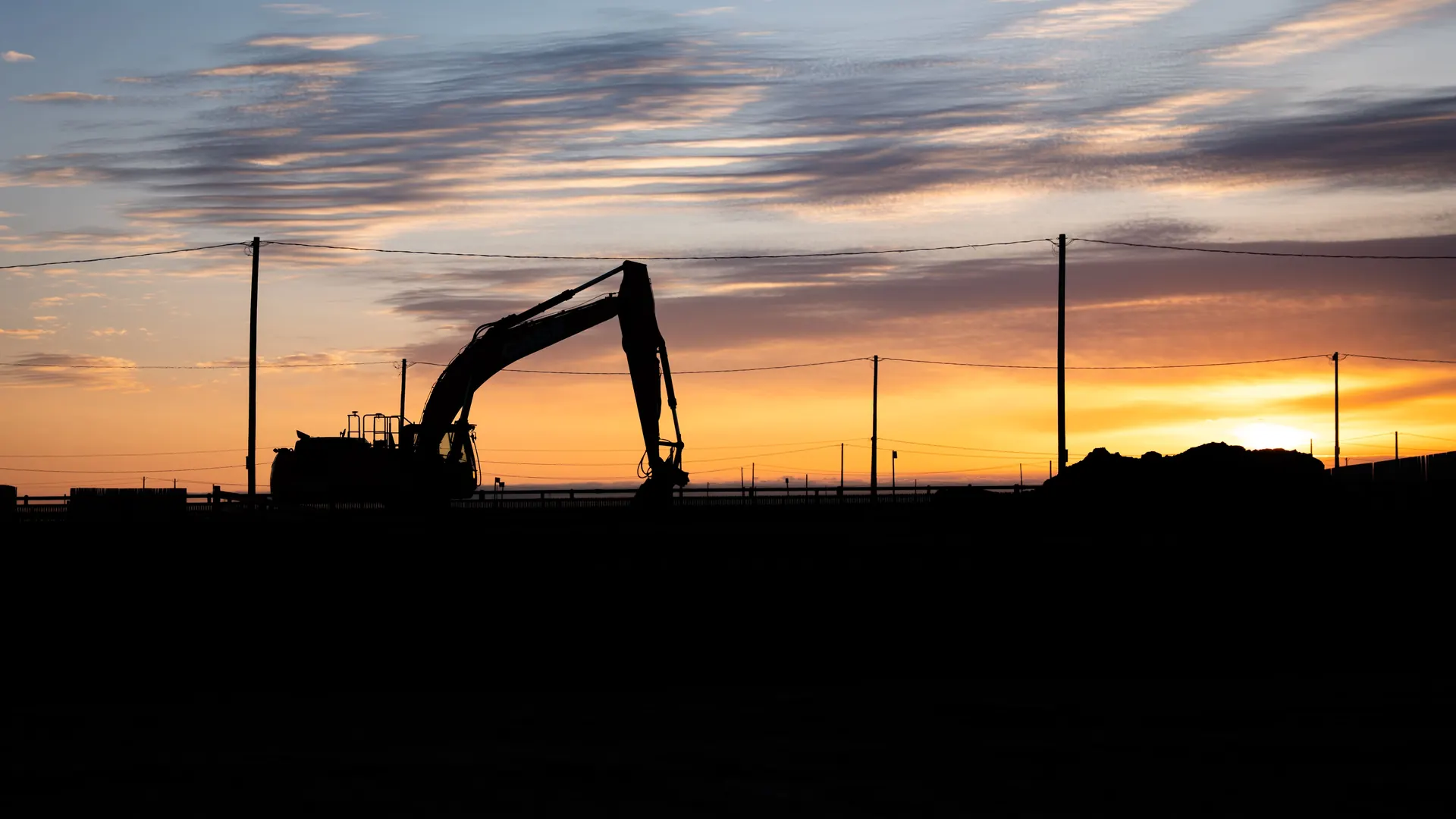 Subterrain excavator silhouetted against an Alberta sunset