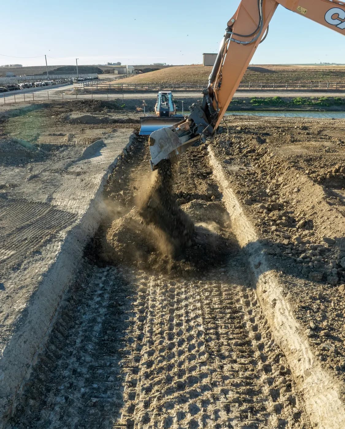 Subterrain excavator cutting a trench at a Southern Alberta feedlot